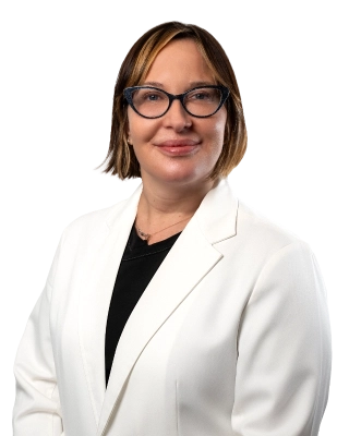 Professional headshot of Dr. Bonnie McKinley wearing a white lab coat, smiling at the camera against a black background. This is a standard medical professional portrait used for clinic or practice identification.